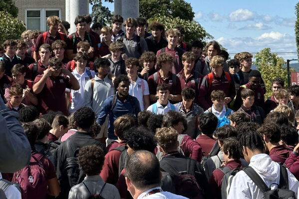 Don Bosco Students outside gathered by a statue of Mary